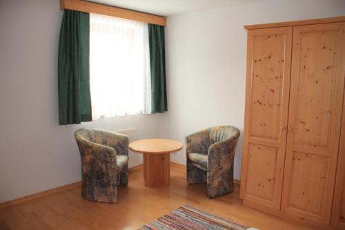 a room with two chairs and a table and a window at Pension Oberhof in Sankt Lorenzen im Lesachtal