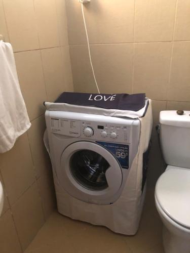 a washing machine in a bathroom next to a toilet at Apartment "Gluecks-Griff" inside "Becici Sunset Apartments" in Budva