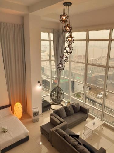 ein Wohnzimmer mit einem Sofa und einem großen Fenster in der Unterkunft Duplex Seaview Comfort Stay in City By IZ in George Town
