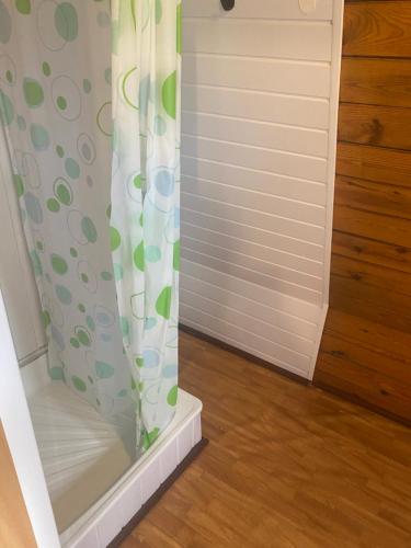 a shower curtain in a room with a door at Domki Topole in Białogóra