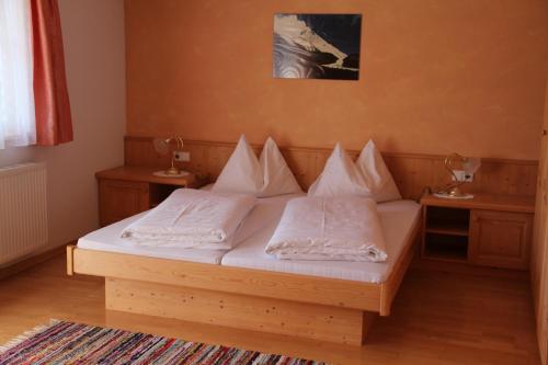 a bedroom with a bed with white pillows on it at Pension Oberhof in Sankt Lorenzen im Lesachtal