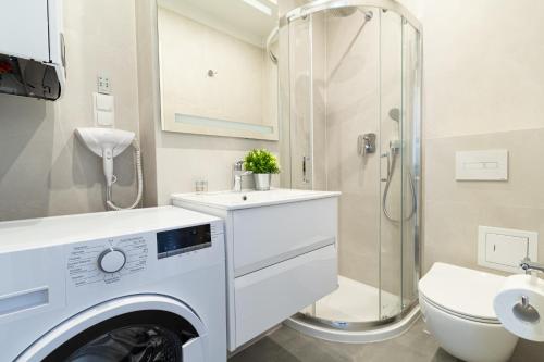 a washing machine in a bathroom with a toilet and a shower at Apartment Kröllgasse I contactless check-in in Vienna