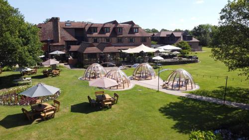 an aerial view of a park with tables and umbrellas at Stirrups Hotel in Bracknell
