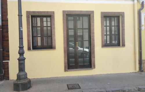 un edificio con tres ventanas y un coche en él en Appartamento centrale, en SantʼAntìoco