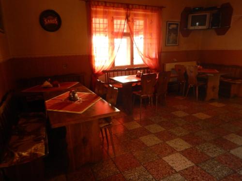 a dining room with tables and chairs and a window at Penzión a reštaurácia pod Hradom, Turńa nad Bodvou in Turna nad Bodvou