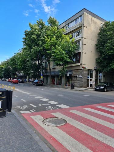 an empty street with a red crosswalk in front of a building at Dolphin Apartment near Neversea Beach in Constanţa