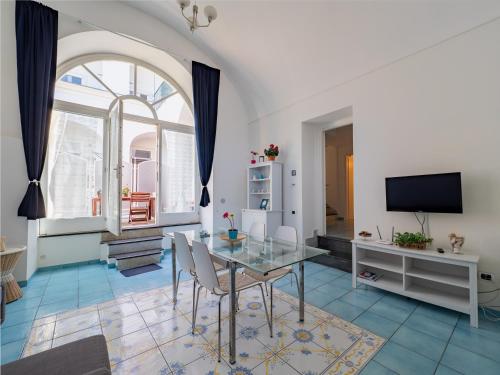 a dining room with a glass table and a tv at Antica Residenza la Vela in Meta