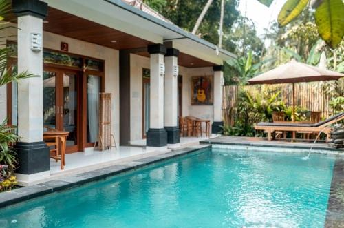 uma casa com piscina em frente a uma casa em D'bunut villa ubud em Ubud