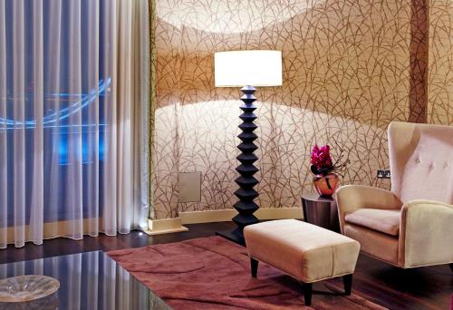 a living room with two chairs and a lamp at Cheval Three Quays at The Tower of London in London