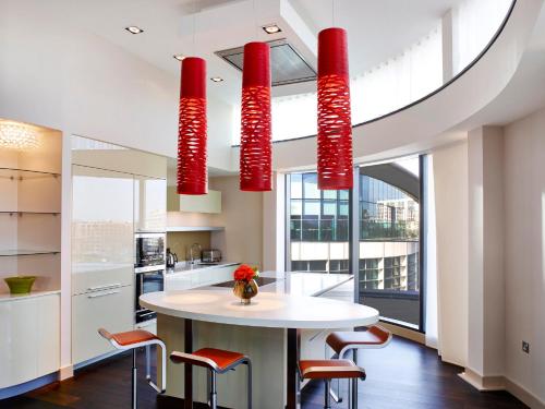 a kitchen with red chandeliers hanging from the ceiling at Cheval Three Quays at The Tower of London in London