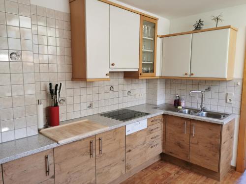 una cocina con armarios de madera y fregadero en Ferienwohnung Mühlburger, en Virgen