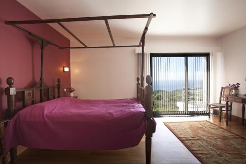 una camera con un letto viola e una grande finestra di Arte da Fuga a Lajes do Pico