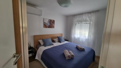 a bedroom with a bed with two towels on it at Apartman Z12 in Kornić