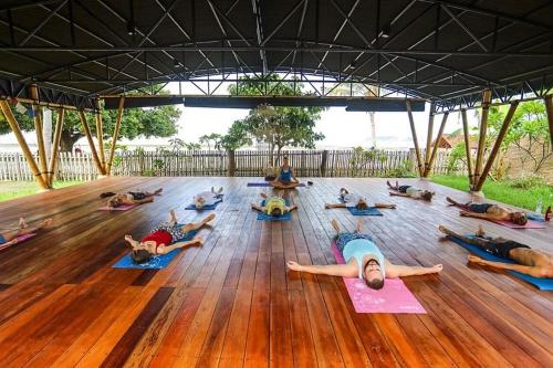 a group of people doing yoga on a wooden floor at Whales and Waves in Lemonga