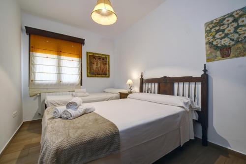 a bedroom with two beds and a window at Villa Carmen in Ronda