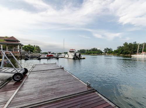 a wooden dock with boats in a river at Mzingazi Waterfront Accommodation, On The Bay Waterfront Villa's in Richards Bay