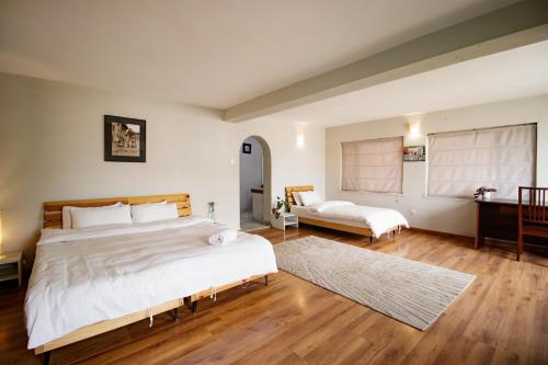a bedroom with a large bed and a desk at Nextdoor Patan in Pātan