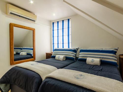 a bedroom with two beds and a mirror at Mzingazi Waterfront Accommodation, On The Bay Waterfront Villa's in Richards Bay