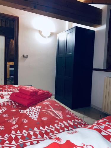 a bedroom with a red bed and a black cabinet at Casa Belvedere in Pieve di Cadore