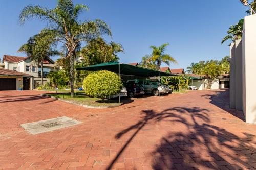 a shadow of a palm tree on a brick driveway at Mzingazi Waterfront Accommodation, On The Bay Waterfront Villa's in Richards Bay