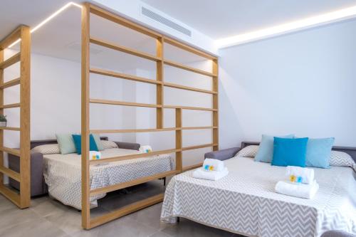 a room with two beds and a bunk bed at Sea Breeze Apartments in Cala Millor
