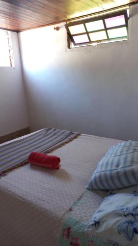 um quarto com uma cama com um objecto vermelho em residência móvel em marica em Maricá