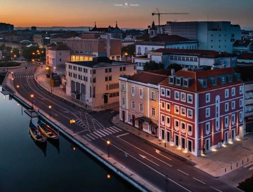 a city with buildings and a river at night at Maraveiro House in Aveiro