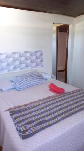 a white bed with a red towel on top of it at residência móvel em marica in Maricá