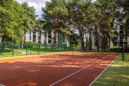 kort tenisowy w parku z drzewami w obiekcie Apartament Nadmorski Dwór- Gdańsk w Gdańsku