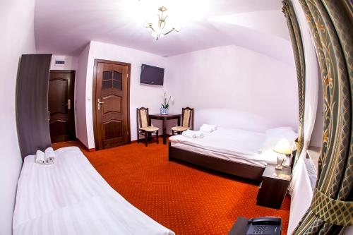 Lubycza KrólewskaにあるHotel "XAVIER"のベッド2台と鏡が備わるホテルルームです。