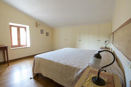 a bedroom with a bed and a lamp on a table at Borgo Colognola - Dimora Storica in Cenerente