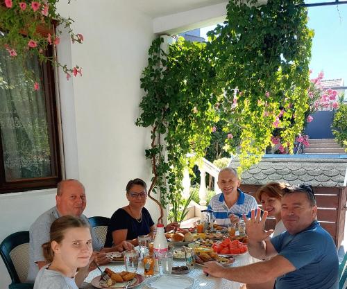 a group of people sitting at a table eating food at Guesthouse DONA in Ulcinj