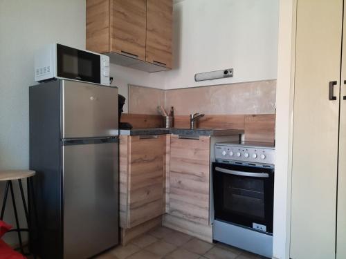 une cuisine avec un réfrigérateur en acier inoxydable et un micro-ondes dans l'établissement studio vue sur mer, au Barcarès