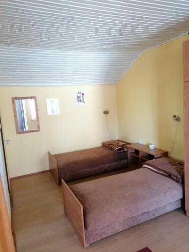 a room with two beds and a table in it at Domek Letniskowy Napiórki in Przechlewo