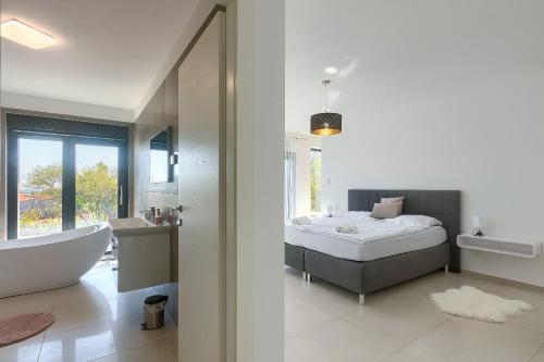 a bathroom with a bed and a bath tub and a sink at Villa Valdo by Istra Vacation in Marčana