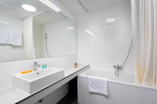 a white bathroom with a sink and a bath tub at Akademis Academia in Dubrovnik