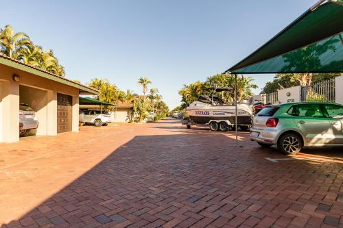 a parking lot with cars parked next to a building at Mzingazi Waterfront Accommodation, On The Bay Waterfront Villa's in Richards Bay