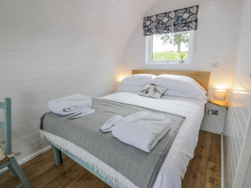 um quarto com uma cama com toalhas brancas em Laird Lodge 2 em Lockerbie