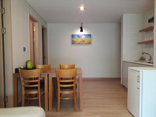 a kitchen and dining room with a wooden table and chairs at Grid Inn Hotel in Seoul