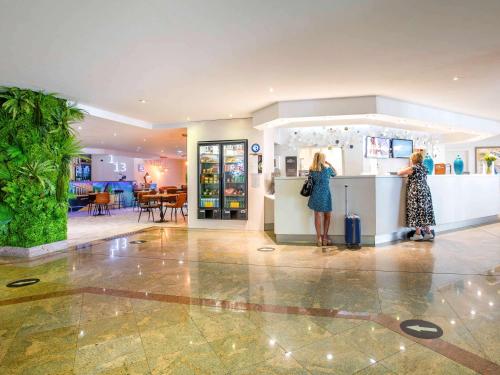 two women standing at a counter in a store at Mercure Marseille Centre Vieux Port in Marseille