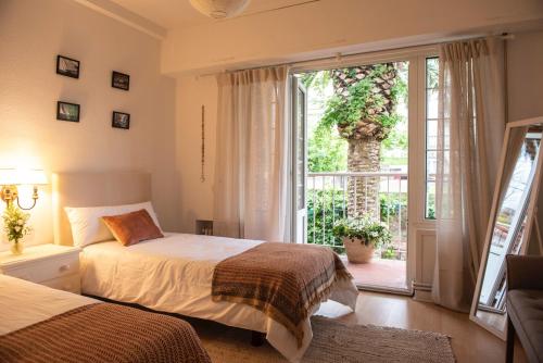 a bedroom with two beds and a large window at Chalet en El Sardinero a 5 minutos de la playa. in Santander