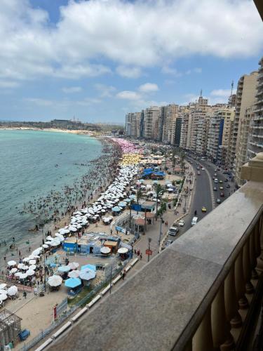 Blick auf einen Strand mit Sonnenschirmen und Menschen in der Unterkunft شقق بانوراما شاطئ الأسكندرية كود 2 in Alexandria