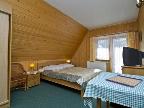 a bedroom with two beds and a flat screen tv at Willa u Krzeptowskich in Kościelisko