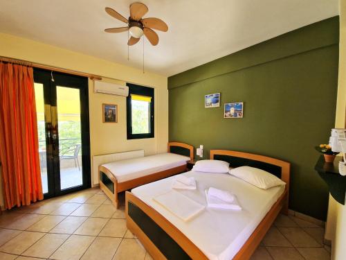 a bedroom with two beds and a ceiling fan at Studios Achileous 1 in AgiaKampos