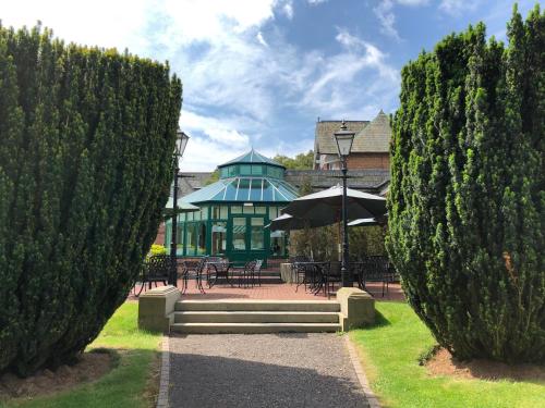 a view of a building from between two trees at Ardencote in Henley in Arden