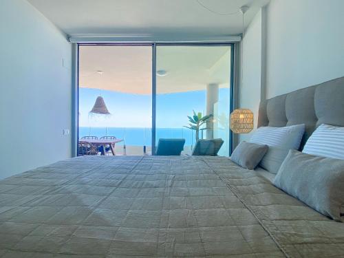 sypialnia z dużym łóżkiem i widokiem na ocean w obiekcie Stupa Hills IV F33G - Superb Sea View Apartment w mieście Benalmádena