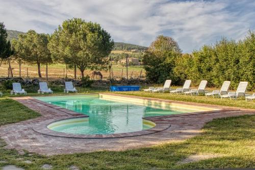 a swimming pool with chairs and chairs in a yard at La Casa Di Campagna in Magione