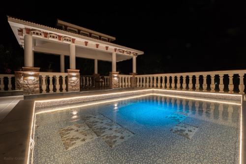 a swimming pool at night with a gazebo at Radhe Krishna Niwas in Udaipur