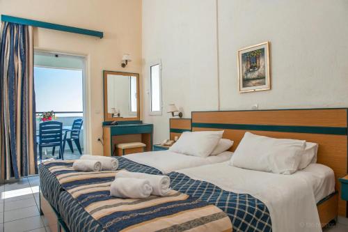 a hotel room with two beds with towels on them at Porto Skala Hotel Village in Skala Kefalonias