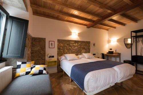 a bedroom with a large bed and a stone wall at Lugar das Marías in Jove